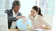 Serious business co-workers looking at a terrestrial globe