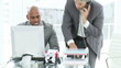 Two disappointed businessmen working at a computer