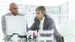 two men working at a computer having an argument