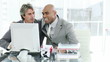 happy colleagues working at a computer in the office