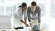 two attractive architects studying blueprints