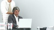 businessmen looking at a laptop in their office with secretary