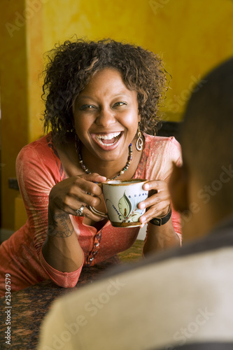 Photo: African-American woman talks to male in kitchen African-American woman talks to male in kitchen