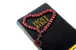 bible with a rosary on a white background
