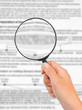 Magnifying glass in hand and business text