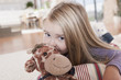 germany, cologne, girl (4-5) with a stuffed toy, lying on carpet