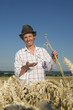 Photo: germany, bavaria, farmer examining wheat growing in field germany, bavaria, farmer examining wheat growing in field
