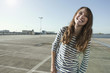 germany, berlin, young woman on parking level, laughing, portrait