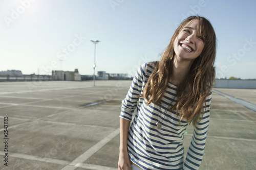 Photo: germany, berlin, young woman on parking level, laughing, portrait germany, berlin, young woman on parking level, laughing, portrait