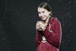 girl standing in rain, holding disposable cup.