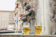 Photo: germany, bavaria, munich, marienplatz, two beer mugs with fountain in background, close-up germany, bavaria, munich, marienplatz, two beer mugs with fountain in background, close-up