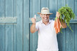 Foto: germany, bavaria, man in front of barn door holding bunch of carrots, smiling, portrait germany, bavaria, man in front of barn door holding bunch of carrots, smiling, portrait