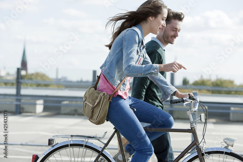 Photo: germany, berlin, young couple with bicycle germany, berlin, young couple with bicycle