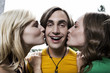 Foto: germany, berlin, two young women kissing man on cheek, laughing, portrait, close-up germany, berlin, two young women kissing man on cheek, laughing, portrait, close-up
