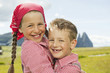 Photo: italy, seiseralm, boy (6-7) and girl (8-9) in field, embracing, smiling, portrait, close-up italy, seiseralm, boy (6-7) and girl (8-9) in field, embracing, smiling, portrait, close-up