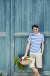 Photo: germany, bavaria, man in front of barn door holding basket with fresh vegetables, smiling, portrait germany, bavaria, man in front of barn door holding basket with fresh vegetables, smiling, portrait