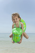 spain, mallorca, girl (4-5) on the beach with inflatable, jumping