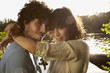 germany, berlin, young couple embracing by river spree,  side view, portrait, close-up