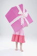 Foto: girl (4-5) holding gift in front of her face girl (4-5) holding gift in front of her face