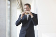 germany, cologne, businessman eating sandwich, portrait