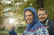 Foto: germany, bavaria, munich, english garden, two men in beer garden, one of them holding a light, smiling, portrait, close-up germany, bavaria, munich, english garden, two men in beer garden, one of them holding a light, smiling, portrait, close-up
