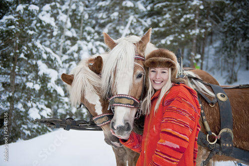 Photo: austria, salzburger land, young woman standing beside horses, smiling, portrait austria, salzburger land, young woman standing beside horses, smiling, portrait