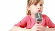 little girl in T-shirt sits and sings in metal microphone