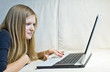 Girl lying on the couch and chatting in her notebook