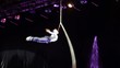 Agile acrobat rapidly spins on tethers in air in circus
