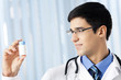 Happy doctor with drug, at office