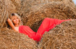 Beautiful blond young woman in a haystack