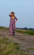 Beautiful blond young woman in a cowboy hat and dress