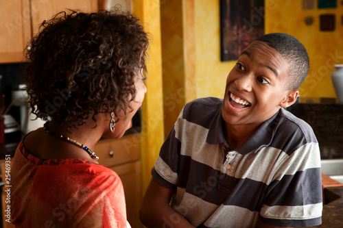 Photo: African-American woman and teen laugh in kitchen African-American woman and teen laugh in kitchen
