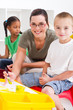 happy teacher helping kindergarten students
