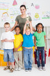 happy preschool boy holding trophy with classmates