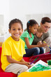 cute indian kindergarten students with teacher painting