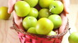 Woman is throwing fruits into basket.