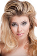 Tempting blonde young woman with large grey eyes holding hair