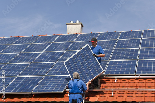 Photo: Two workmen are mounting solar Two workmen are mounting solar