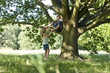 A young woman talking to her boyfriend up a tree