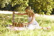 A young woman opening a picnic basket
