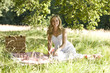 A young woman sitting on a picnic blanket