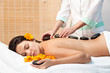 Woman getting a hot stone massage at spa salon