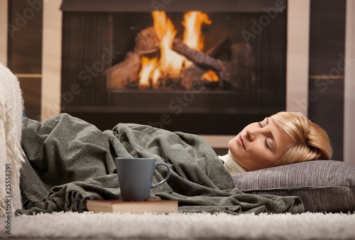 Foto: Woman sleeping beside fireplace Woman sleeping beside fireplace
