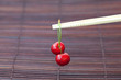 cherry and chopsticks on bamboo mat cherry and chopsticks on bamboo mat