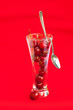 glass of cherry and spoon on a red background glass of cherry and spoon on a red background