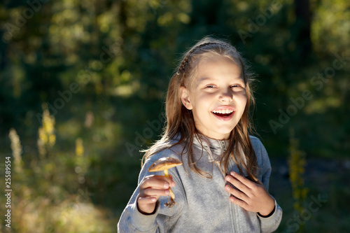 Photo: Attractive portrait of smiling little girl with mushroom Attractive portrait of smiling little girl with mushroom