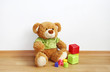 Toys - Teddy bear with cubes on laminate floor Toys - Teddy bear with cubes on laminate floor