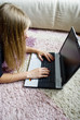 Girl lying on the floor and using her notebook