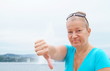 Unzufriedene ältere Frau zeigt finger nach unten. Sample text.
